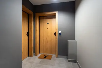 a hallway with a wooden door and a rug at Sunflower Apartment Kalwaryjska Street in Kraków