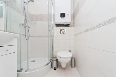 a white bathroom with a toilet and a shower at Dietla Old Town, Sun & Snow in Kraków