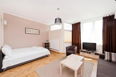 a bedroom with a bed and a tv and a couch at Dietla Old Town, Sun & Snow in Kraków