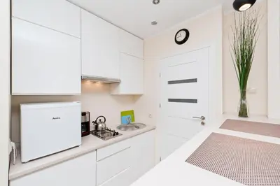 a white kitchen with a sink and a refrigerator at Dietla Old Town, Sun & Snow in Kraków