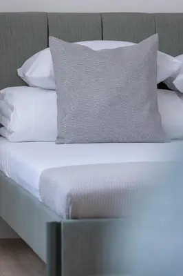 a bed with white sheets and a pillow on it at Studio apartment - Starowiślna 69 street in Kraków
