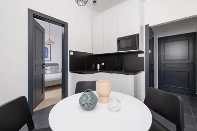 a kitchen and dining room with a white table and chairs at Studio apartment - Starowiślna 69 street in Kraków