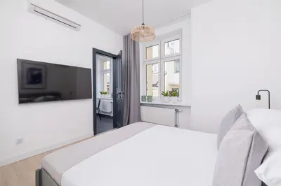 a white bedroom with a bed and a window at Studio apartment - Starowiślna 69 street in Kraków