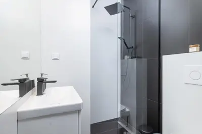 a white bathroom with a sink and a shower at Studio apartment - Starowiślna 69 street in Kraków