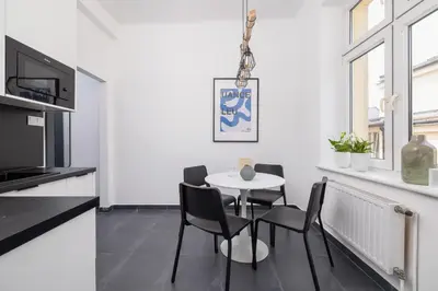 a kitchen and dining room with a table and chairs at Studio apartment - Starowiślna 69 street in Kraków
