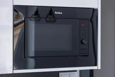 a black microwave oven sitting inside of a kitchen at Studio apartment - Starowiślna 69 street in Kraków