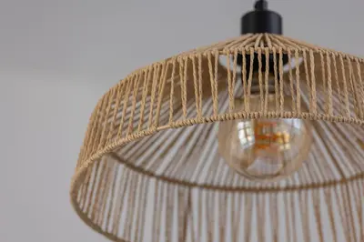 a rattan lamp with ahat on top of it at Studio apartment - Starowiślna 69 street in Kraków