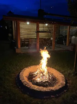 a fire pit in the middle of a yard at night at Grelówka Apartament in PyzÃ³wka