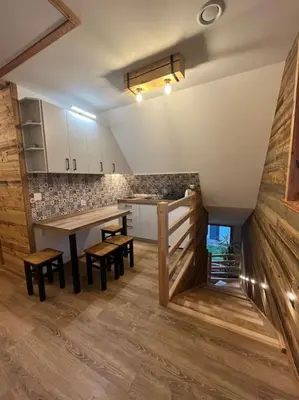 a kitchen with a table and chairs in a room at Grelówka Apartament in PyzÃ³wka