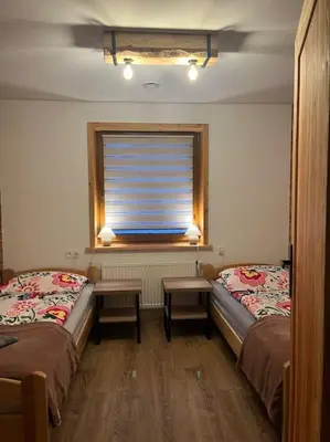 a room with two twin beds and a window at Grelówka Apartament in PyzÃ³wka