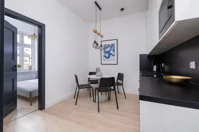 a kitchen and dining room with a table and chairs at 2-bedroom apartment - Starowiślna 69 street in Kraków