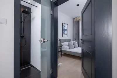 a bathroom with a glass door leading to a bedroom at 2-bedroom apartment - Starowiślna 69 street in Kraków