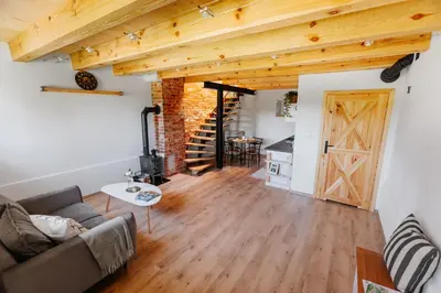 a living room with a couch and a barn door at JÓZEFÓWKA Stara Stodoła in Zagórze