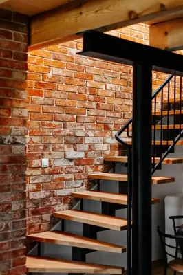 a brick wall with a staircase in front of a brick wall at JÓZEFÓWKA Stara Stodoła in Zagórze