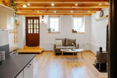 a living room with a couch and a table at JÓZEFÓWKA Stara Stodoła in Zagórze