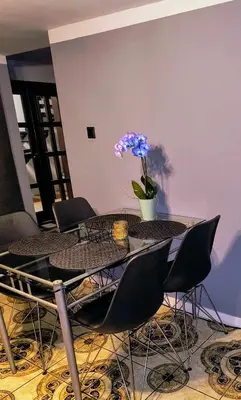 a dining room table with chairs and a vase of flowers at Dom na wsi w okolicy ENERGYLANDIA ZATOR in Łączany