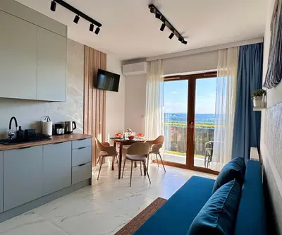 a kitchen and dining room with a table and a kitchen and a room with at Vidok Residence Apartments in Młoszowa
