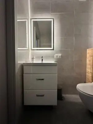 a white bathroom with a sink and a mirror at Vidok Residence Apartments in Młoszowa