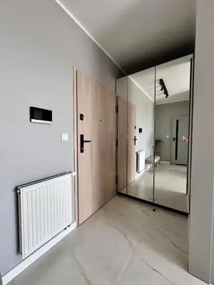 an empty room with a large mirror and a hallway at Vidok Residence Apartments in Młoszowa