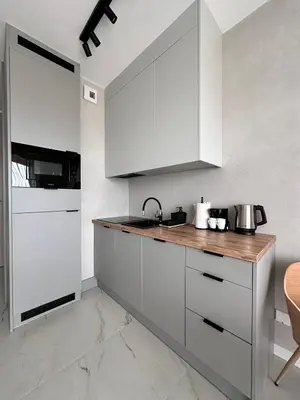 a kitchen with white cabinets and a wooden counter top at Vidok Residence Apartments in Młoszowa