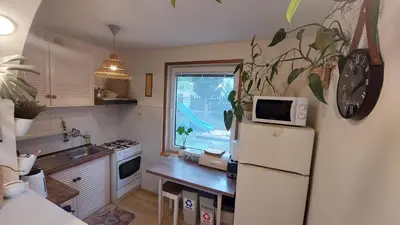 a kitchen with a refrigerator and a table with a microwave at Cottage Zawoja z Jacuzzi in Zawoja