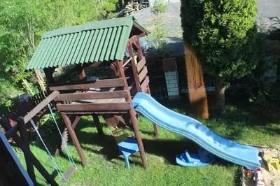 a playground with a swing and a slide at Cottage Zawoja z Jacuzzi in Zawoja