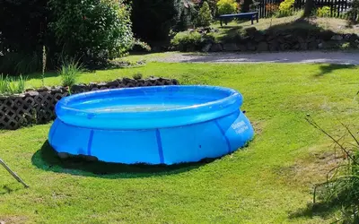 a blue bucket sitting on the grass in a yard at Cottage Zawoja z Jacuzzi in Zawoja
