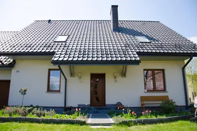 a white house with a bench in front of it at Noclegi Przy Starej Stodole in Jankowice