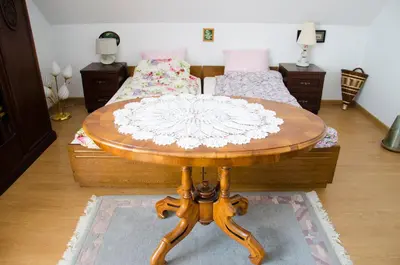 a wooden table in a room with a bed at Noclegi Przy Starej Stodole in Jankowice