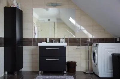 a bathroom with a sink and a washing machine at Noclegi Przy Starej Stodole in Jankowice