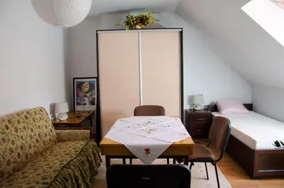 a living room with a table and a bed at Noclegi Przy Starej Stodole in Jankowice