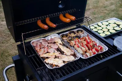 two pans of meat and vegetables on a grill at Noclegi Przy Starej Stodole in Jankowice