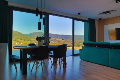 a living room with a green couch and a table at Beskid Island in Dobra