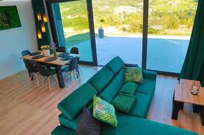 a living room with a green couch and a table at Beskid Island in Dobra