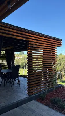 a wooden pergola on a patio with a table at Domek Stróski in Wola Stróska