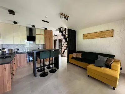 a kitchen and living room with a couch and a table at Domek Stróski in Wola Stróska
