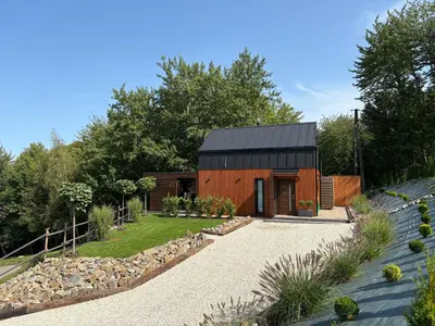 a barn conversion with a black roof and a gravel driveway at Domek Stróski in Wola Stróska