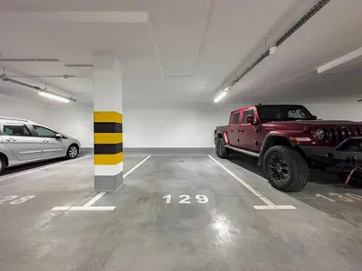 a parking garage with a red truck parked in it at Klimeckiego Luxury Apartments 215 in Kraków