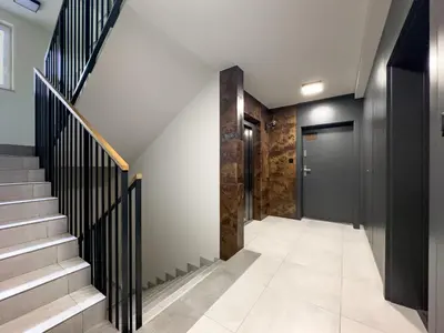 a hallway with stairs and a black door at Klimeckiego Luxury Apartments 215 in Kraków