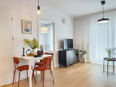 a living room with a table and chairs and a kitchen at Klimeckiego Luxury Apartments 215 in Kraków