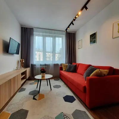 a living room with a brick wall and a window at Nowa Huta - Stay Here in Kraków