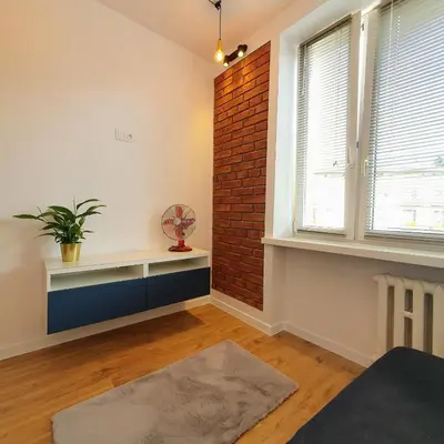 a living room with a red couch and a table at Nowa Huta - Stay Here in Kraków