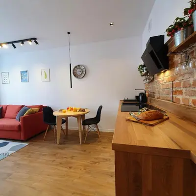 a hallway with white walls and wooden cabinets at Nowa Huta - Stay Here in Kraków