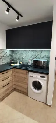 a kitchen with a washing machine and a sink at Apartment Jerzmanowskiego Krakow in Kraków