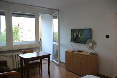 a living room with a table and a flat screen tv at Apartment Jerzmanowskiego Krakow in Kraków
