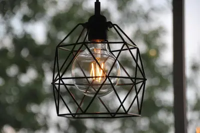 a light bulb in a cage hanging from a ceiling at Apartment Jerzmanowskiego Krakow in Kraków