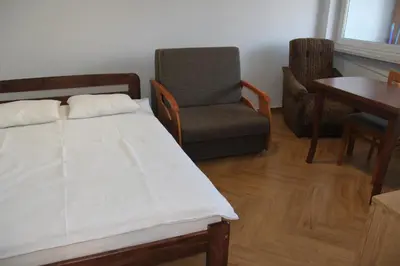 a bedroom with a bed and a chair and a table at Apartment Jerzmanowskiego Krakow in Kraków