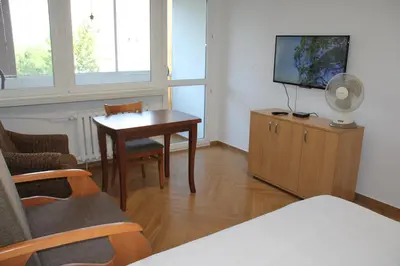 a living room with a tv and a table and chairs at Apartment Jerzmanowskiego Krakow in Kraków