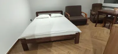 a bed in a room with a table and a chair at Apartment Jerzmanowskiego Krakow in Kraków
