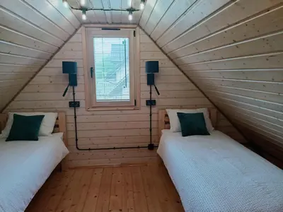 two beds in a small room with a window at Winnica Zatorska in Olszyny